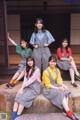 A group of young women sitting on a stone bench.