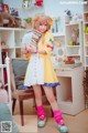 A woman in a yellow dress holding a stack of books.