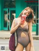 A woman in a bathing suit drinking a drink.