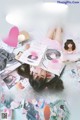 A woman laying on top of a bed covered in magazines.