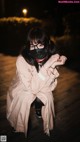 A woman wearing a face mask sitting on a wooden floor.