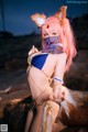 A woman in a bikini with pink hair and a fox mask.