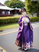 A woman in a purple dress is posing for a picture.