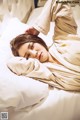 A woman laying in bed with her head on a pillow.